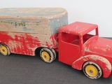 a red toy truck with a box on the back of it