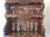 a wooden shelf with wine glasses on top of it