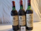 Trois bouteilles de vin sont posées sur une table, accompagnées d'une étiquette de prix