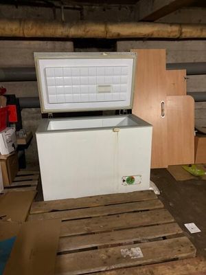 un congélateur coffre blanc posé sur une palette dans une pièce