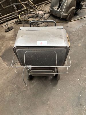 une petite boîte métallique posée sur un chariot dans un garage