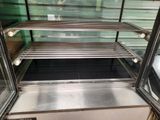 une vitrine en verre contenant beaucoup de nourriture