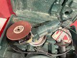 a green box with a tool in it on a red surface