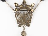 a close up of a necklace with black beads and a crown on it