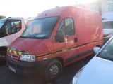 une camionnette rouge garée sur un parking à côté d'autres voitures