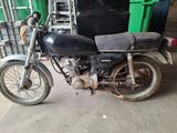a black motorcycle parked in a garage next to a green bin