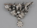 a silver brooch with black and white stones on it