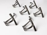 six pairs of silver cuff rings on a white surface