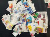 a pile of stamps on a table with a pair of scissors