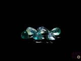 three pieces of green and blue sapphire on a black background