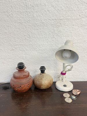 a table with a lamp, a vase, and some coins on it