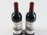 two bottles of wine sitting next to each other on a table