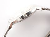 wrist of a watch on a white surface with a white background