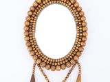 wooden beaded mirror with tassels and tassels hanging from it