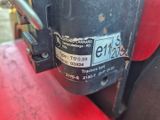 a close up of a red tractor with a number plate on it