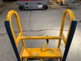 a yellow and blue hand truck sitting in a garage