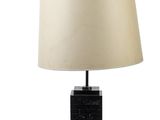 une lampe de table en marbre noir avec un abat-jour beige sur fond blanc