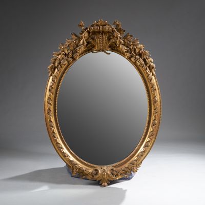 un miroir richement sculpté, doté d'un cadre doré sur un fond blanc