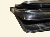 a black leather wallet with a gold clasp on it
