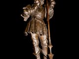 bronze statue of a man holding a staff on a pedestal