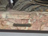 a statue of a woman sitting on top of a marble box