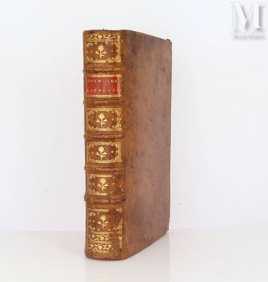 un vieux livre posé sur une table blanche à côté d'un mur blanc