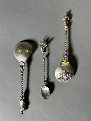 three silver spoons and a spoon with a handle and a spoon with a spoon on it