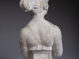 statue of a woman in a white dress with her back to the camera