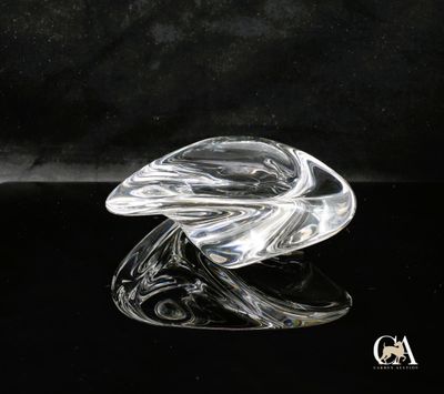 une image représentant une sculpture en verre représentant une feuille posée sur une surface noire