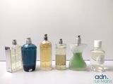 several bottles of perfume are lined up on a white surface