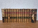 a stack of old books sitting on top of a wooden table