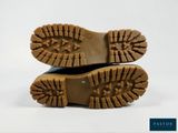 the soles of a pair of brown boots on a white background
