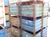 many blue crates stacked on top of each other in the dirt