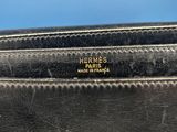 a black leather purse with a gold logo on the front