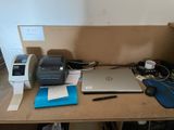 un bureau sur lequel se trouvent un ordinateur portable, une imprimante et d'autres objets