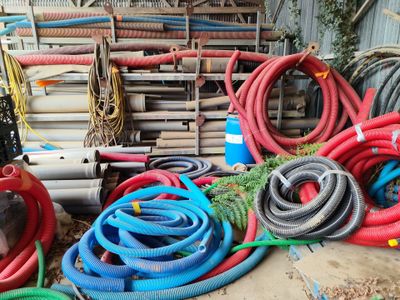 de nombreux tuyaux de différentes couleurs posés par terre les uns à côté des autres