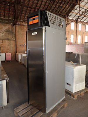 an image of a refrigerator in a warehouse with other appliances
