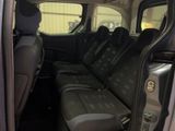 the back seats of a car with the door open and the driver ' s seat folded down