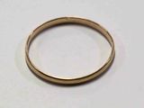une image d'un gros plan d'une bague en or sur une surface blanche