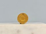 an image of a gold coin sitting on top of a white marble block
