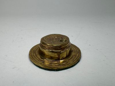 an old brass plate with a lid on a white surface