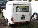 a small white van that is parked in the grass