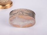 a gold ring sitting on top of a white table next to a gold box