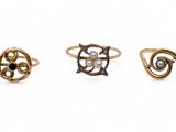 three different rings with pearls on them on a white background