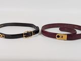 pair of black and red leather bracelets with gold buckles