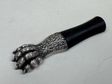 une patte d'animal en métal avec un manche noir sur un fond blanc
