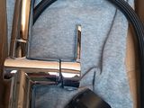 a silver faucet and a black mouse in a box