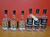 Plusieurs bouteilles d'alcool sont alignées sur une table en bois