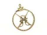 a close up of a gold plated pendant with two swords in a circle
