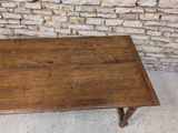 a wooden table that is sitting in front of a brick wall